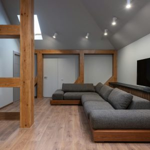 Interior of cozy prestige living room with spacious soft gray sofa illuminated with bright lamps